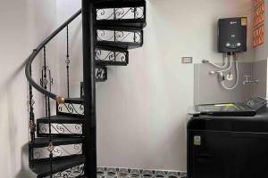 - un escalier en colimaçon noir dans une chambre avec un réfrigérateur dans l'établissement Cómodo apto, excelente ubicación Sabaneta, à Sabaneta