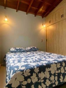 - une chambre dotée d'un lit avec une couverture bleue et blanche dans l'établissement Cómodo apto, excelente ubicación Sabaneta, à Sabaneta