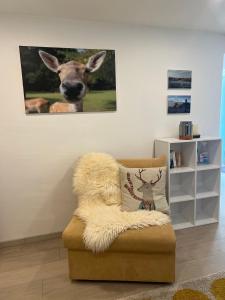 a chair with a picture of a deer on the wall at Schwarzwald Boutique-Apartment HAUS REHGARTEN in Gaggenau