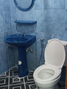 a bathroom with a blue sink and a toilet at Hug Glur House Tour and Hostel in Chiang Mai