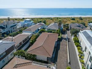 マウント・マウンガヌイにあるSeaside Beach Retreat - Outdoor livingの家屋と海岸の空中を望む