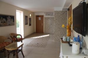 a living room with a television and a room with a hallway at Hotel Firenze in Bellaria-Igea Marina
