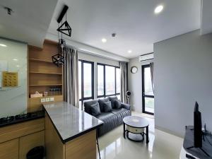 a kitchen and a living room with a couch at Palam Mansion at Apartment One Residence in Batam Center