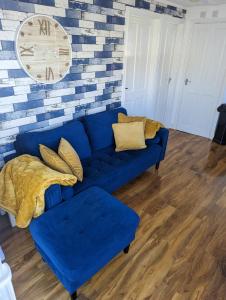 ein blaues Sofa im Wohnzimmer mit Ziegelwand in der Unterkunft Savannah-by-the-sea in Bridlington