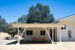 馬里波薩的住宿－Peaceful Mariposa Home near Yosemite National Park，建筑前带长凳的野餐棚