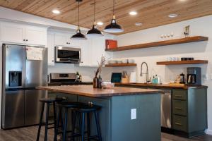 una cocina con una isla azul con taburetes de bar en Peaceful Mariposa Home near Yosemite National Park, en Mariposa