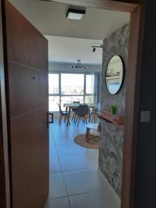 a hallway with a room with a table and a mirror at Calidez, confort y relax. in Trelew