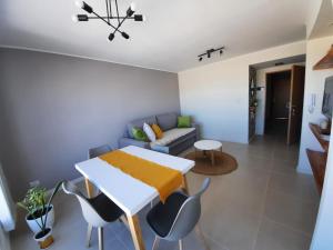 a living room with a table and chairs and a couch at Calidez, confort y relax. in Trelew