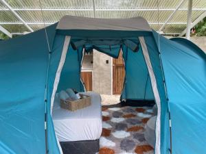 a blue tent with a bed in a room at Serenity Glamping in Puerto Viejo