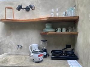 a kitchen with a counter with a blender and plates at Serenity Glamping in Puerto Viejo