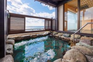 a swimming pool with a view of the ocean at Sado Resort Hotel Azuma in Sado