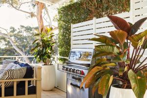 eine Außenküche mit Pflanzen und einem Grill auf einer Terrasse in der Unterkunft Arabella in Nelson Bay