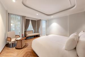 ハノイにあるLa Siesta Classic Hang Thungのベッドルーム(大きな白いベッド1台、椅子付)