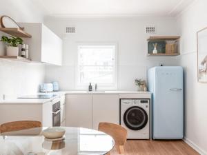 a kitchen with a white refrigerator and a table at No 6 ShoalHaven in Shoal Bay
