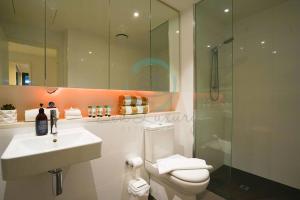 een badkamer met een wastafel, een toilet en een douche bij Zen Seaside 1BR Waterfront Apt in Darwin