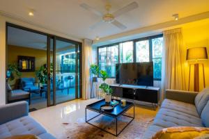 uma sala de estar com um sofá e uma televisão de ecrã plano em Zen Seaside 1BR Waterfront Apt em Darwin