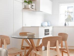 a dining room table and chairs in a kitchen at No 6 ShoalHaven - 1 bed option in Shoal Bay