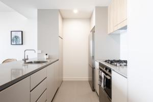 uma cozinha branca com um lavatório e um fogão em The Aire em Newcastle