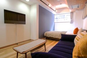 un salon avec un canapé et une télévision à écran plat dans l'établissement J-Court Oshiage, à Tokyo