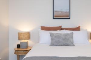 a bedroom with a white bed and a table with a lamp at The Aire in Newcastle