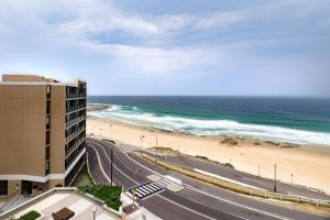a view of a beach and a building and the ocean at The Aire in Newcastle