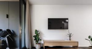 a living room with a tv on a white wall at The Muse - 1 bed option in Newcastle