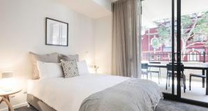 1 dormitorio con 1 cama y balcón con mesa en The Muse - 1 bed option, en Newcastle