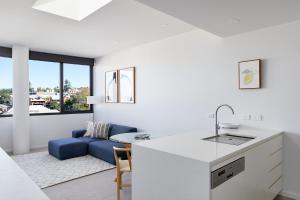 cocina y sala de estar con sofá azul en The Loft, en Newcastle