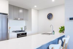 a kitchen with white cabinets and a counter top at The Hideaway in Newcastle