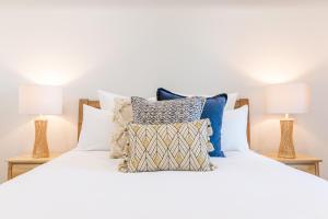 sypialnia z białym łóżkiem z poduszkami i 2 lampami w obiekcie The Hideaway w mieście Newcastle