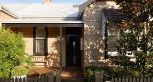 a white house with a black door and a fence at The Willows in Wickham