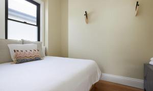 a bedroom with a white bed and a window at The Willows in Wickham +9 photos