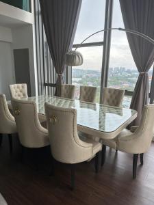 a glass table and chairs in a room with a window at INAP DESA EVO BANGI in Bandar Baru Bangi