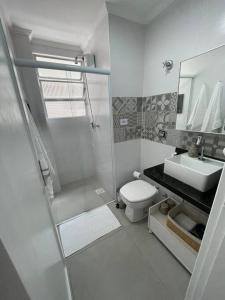 a bathroom with a shower and a toilet and a sink at Apartamento quarteirão da praia (Boqueirão) in Santos