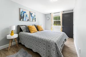 a white bedroom with a bed and a window at One bedroom apartment Moncton North ! in Moncton