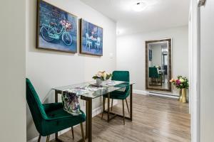 une salle à manger avec une table en verre et des chaises vertes dans l'établissement One bedroom apartment Moncton North !, à Moncton