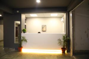 une chambre avec deux plantes en pot et un mur blanc dans l'établissement Country Inn & Suites By Turtle, à Mumbai