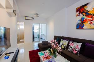 a living room with a couch and a painting on the wall at W Phuket in Phuket +48 photos