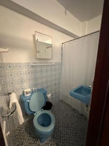 y baño con aseo azul y lavamanos. en Vieques Tropical Guest House, en Vieques