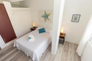 a small bedroom with a bed and two lamps at Vieques Tropical Guest House in Vieques