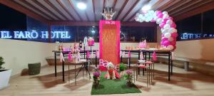 una stanza con tavoli decorati in rosa e viola di EL FARO HOTEL a Chala