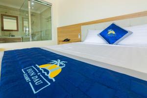 Un dormitorio con una cama con una toalla azul. en Hon Dau Resort, en Do Son