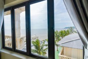 a room with a window looking out at the beach at Hon Dau Resort in Ðố Sơn