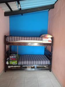 a room with two bunk beds against a blue wall at Villas Norita in Ibarra