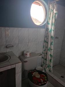 a small bathroom with a toilet and a window at Villas Norita in Ibarra