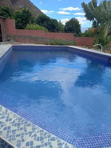 una gran piscina con agua azul en un patio en Villas Norita en Ibarra