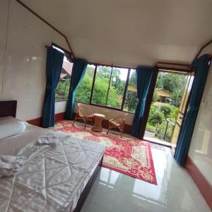 a bedroom with a bed and a large window at Brown House Resort in Can Tho