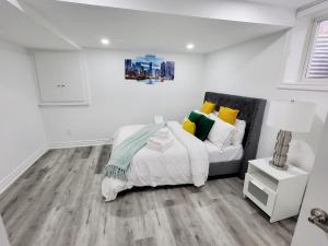 a white bedroom with a bed and a couch at Feel Like Home/ Bs Mississauga in Mississauga