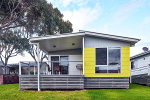 una casa amarilla y blanca en un patio en NRMA Merimbula Beach Holiday Resort, en Merimbula