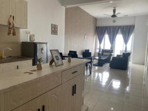 a kitchen and a living room with a couch and a table at Bayu Apartment Services in Kuah